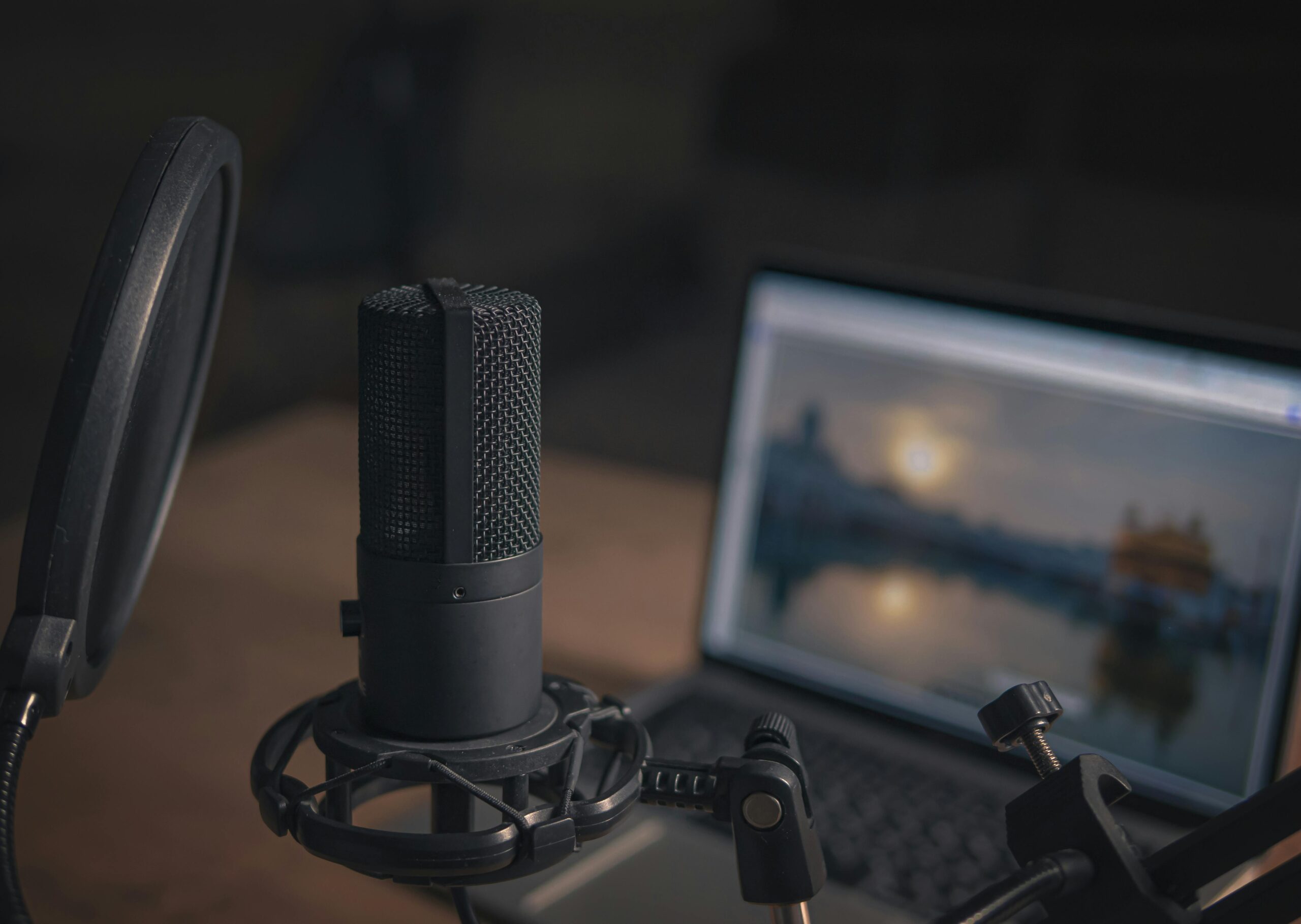Home Close-up of a microphone with a pop filter and laptop, ideal for modern studio production.