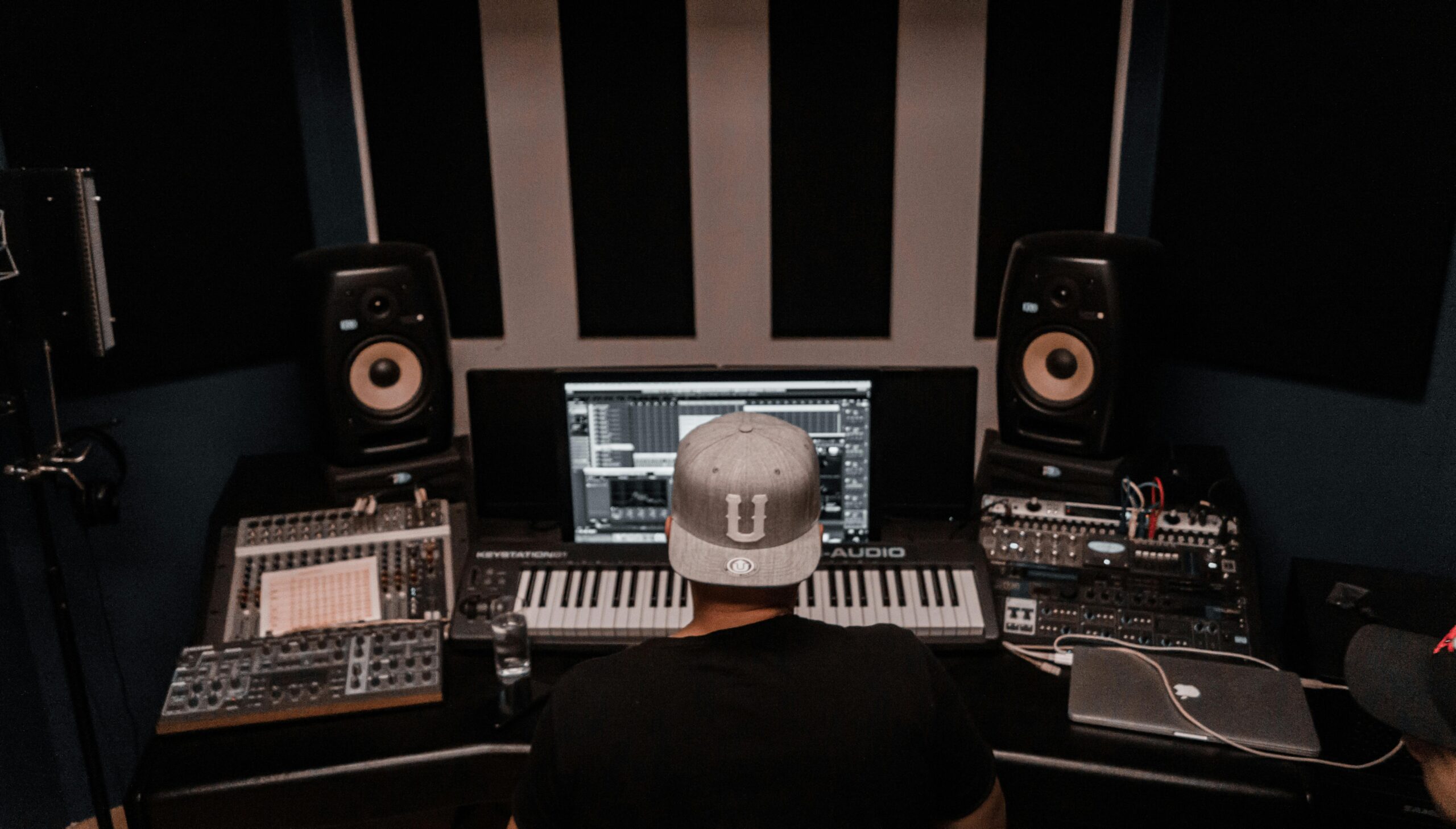 Home A music producer working in a modern studio with keyboards and monitors. Perfect for music industry visuals.
